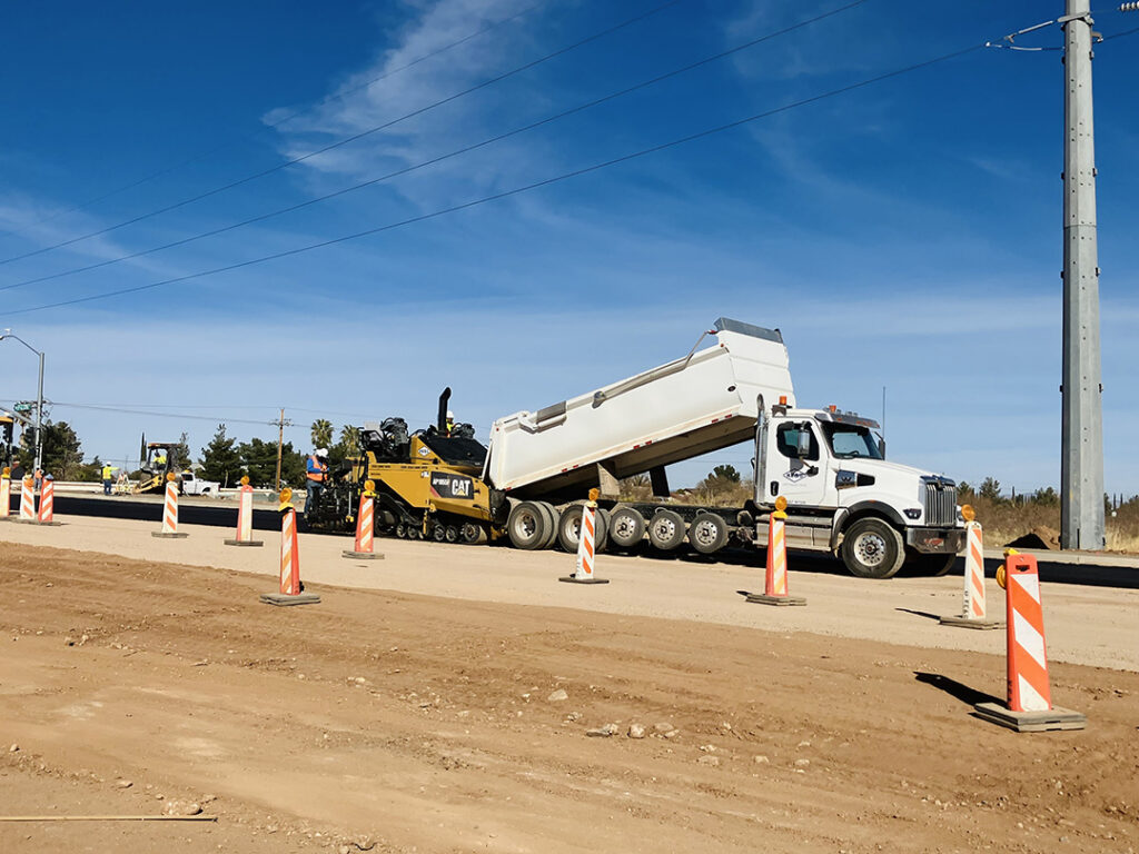 semi dumping asphalt into paver